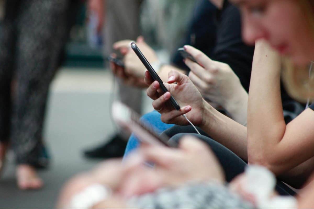 Cómo proteger los datos de tu smartphone: asegura la información en tu Smartphone con Estas Estrategias 3 Personas que usan teléfonos celulares en público.